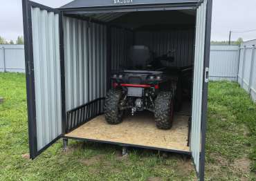 Двускатная крыша и стильный оттенок RAL 7024: гараж SKOGGY на дачном участке