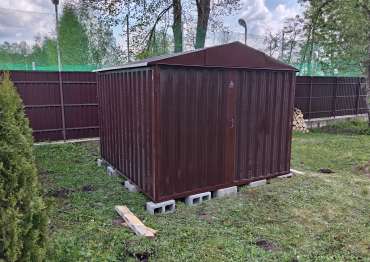 Хозблок SKOGGY коричневого цвета RAL 8017 на дачном участке